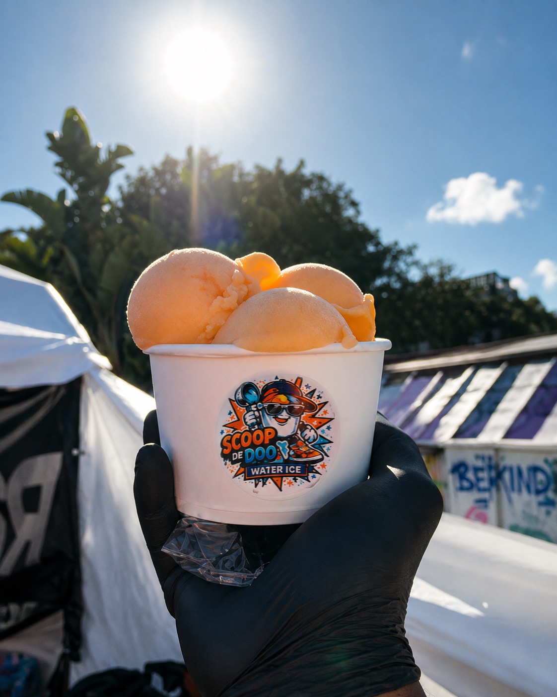 A Big Gus cup packed with three overflowing scoops of mango water ice in the sun