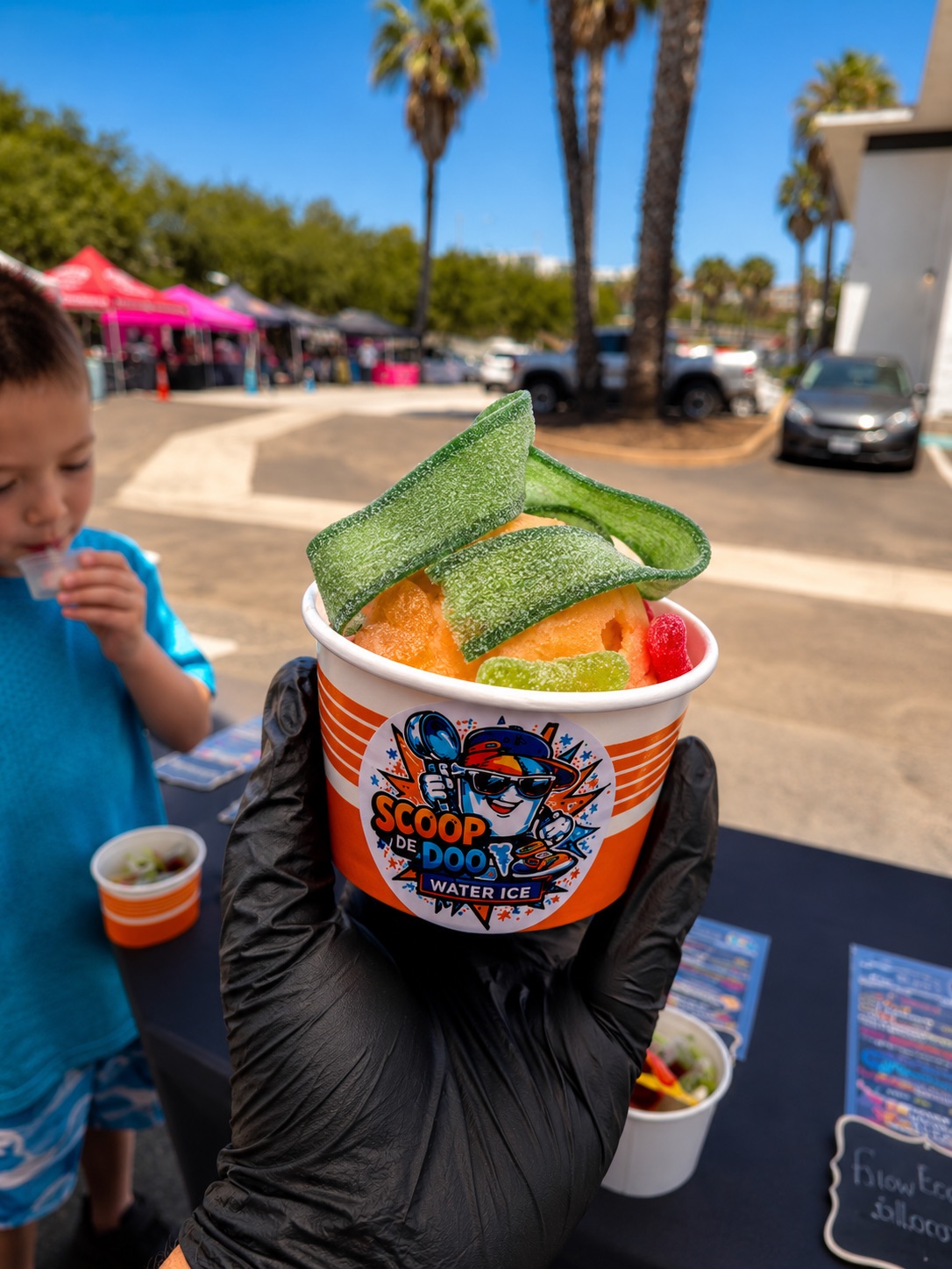 A cup of water ice loaded with sour belts at a community event